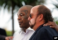 عکسی از توبک در کنار مایک تایسون قهرمان بوکس سنگین وزن جهان در دهه ۱۹۹۰ میلادی.