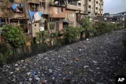 Garbage chokes a polluted canal in Mumbai, India, June 4, 2018.