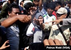Massa yang menolak deklarasi 2019 Ganti Presiden membakar topi atribut peserta deklarasi.