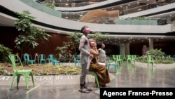 A boy stands with his family in the Discovery vaccination site as he waits to receive his first jab of Pfizer/BioNTech vaccine against COVID-19 in Sandton, Johannesburg, Dec. 15, 2021.