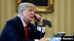 FILE - U.S. President Donald Trump speaks by phone with the Saudi Arabia's King Salman in the Oval Office at the White House in Washington, Jan. 29, 2017.