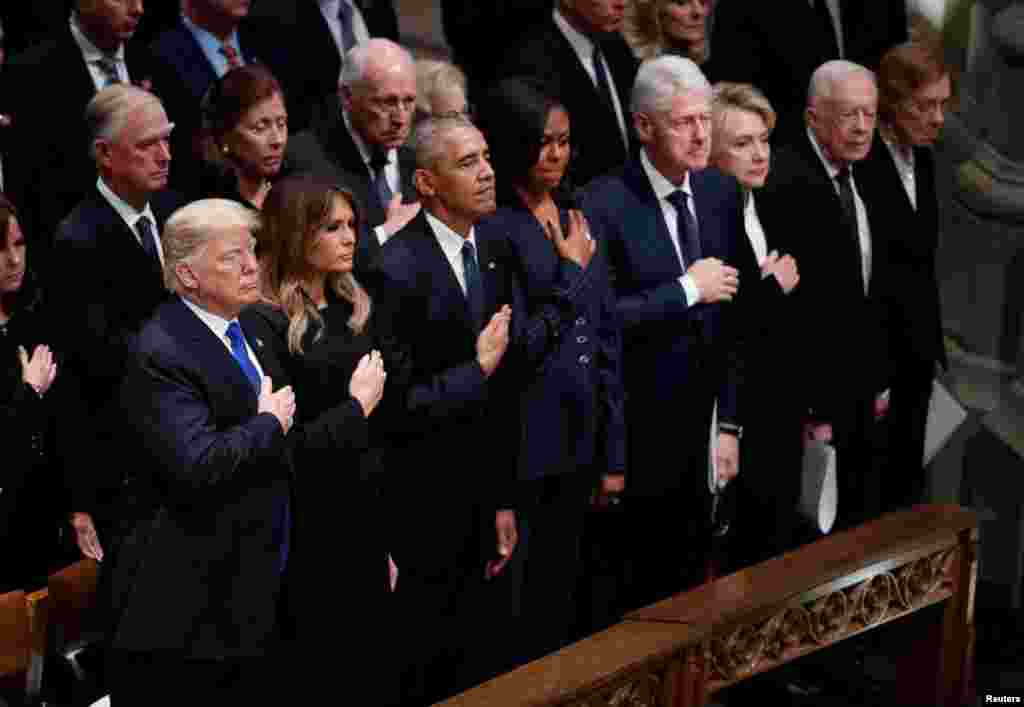 President Donald Trump and first lady Melania Trump stand with former President Barack Obama, former first lady Michelle Obama, former President Bill Clinton, former first lady Hillary Clinton, former President Jimmy Carter and former first lady Rosalynn Carter in the front row at the state funeral for former U.S. President George H.W. Bush at the Washington National Cathedral, Dec. 5, 2018.