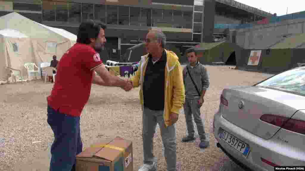 Un homme apport des habits et des jouets aux migrants qui vivent dans le centre d&#39;accueil de la Croix Rouge italienne derrière la gare de Tiburtina, Rome, 5 octobre 2015 (Nicolas Pinault/VOA). &nbsp;