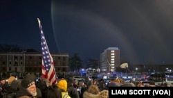 ພວກ​ປະ​ທ້ວງ​ໄດ້​ເຕົ້າ​ໂຮມ​ກັນ​ທີ່​ຄຸກ​ສູນ​ກາງ​ກັກ​ຂັງ​ໃນ​ນະ​ຄອນ​ຫຼວງ​ວໍ​ຊິງ​ຕັນ(​Detention Facility prison in Washington)ໃນ​ຕອນ​ຄ່ຳ​ວັນ​ຈັນ​ທີ 20 ມັງ​ກອນ 2025.