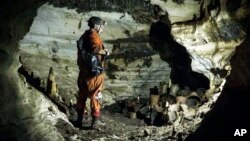 Archaeologist Guillermo de Anda stands next to pre-columbian artifacts in a cave at the Mayan ruins of Chichen Itza, Yucatan, Mexico, Tuesday, Feb. 19, 2019. Karla Ortega/Mexico's National Institute of Anthropology and History via AP)