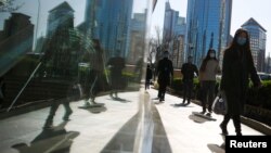 2020年4月2日北京商务区高峰时段人们戴着口罩上班。