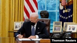 پرزیدنت بایدن دستورهای اجرایی را در دفتر کار خود در کاخ سفید امضا می کند. ۲۶ ژانویه ۲۰۲۱