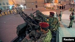 FILE - Houthi fighters in army uniforms patrol outside the presidential palace in Sana'a, Yemen, Feb. 6, 2015.