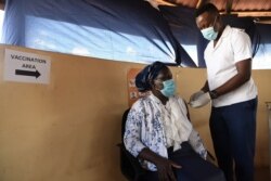 FILE - A health worker receives a dose of the Oxford/AstraZeneca COVID-19 vaccine in Francistown, Botswana, March 26, 2021.