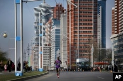 A participant of the Pyongyang marathon runs down Mirae Scientist Street, April 9, 2017, in Pyongyang, North Korea.