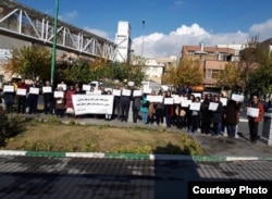In this November 26, 2018 photo of protest by Iranian doctors outside parliament in Tehran, some protesters hold up a sign saying detained activist Farhad Meysami needs medical treatment at a well-equipped hospital.