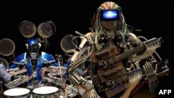 Robot guitarist "Mach" and robot drummer "Ashura" (L), members of a robot rock band "Z-Machines", perform music during the two day art and technology event "Maker Faire Tokyo."