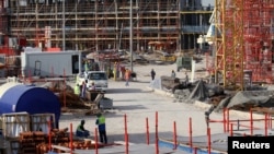 FILE - Migrant laborers work at a construction site in Doha, Qatar, March 26, 2016. 