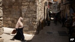 A woman carries her prayer mat to the first Friday prayers at the Dome of the Rock Mosque during the Muslim holy month of Ramadan Jerusalem's Old City , Friday, April 16, 2021. (AP Photo/Maya Alleruzzo)