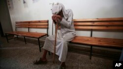 FILE - An elderly man waits to be treated for a suspected cholera infection at a hospital in Sana'a, Yemen, July 12, 2017.