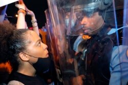 A protester and a police officer stare at one another on the Crescent City Connection bridge, which spans the Mississippi River in New Orleans, June 3, 2020, during a protest over the May 25 death of George Floyd.