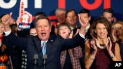 With his wife Karen at his side Republican presidential candidate Ohio Gov. John Kasich cheers with supporters, Feb. 9, 2016, in Concord, N.H., at his primary night rally.