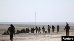 Pasukan Demokratik Suriah berjalan di kawasan yang mereka ambil alih dari ISIS di Hasaka, Suriah, 19 Februari 2016. 