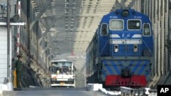 지난 2004년 북한 열차와 버스가 북한과 중국을 잇는 교량을 건너 접경도시 중국 단둥으로 들어오고 있다. (자료사진)