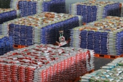 Seorang petugas memakai masker saat memeriksa tumpukan karung beras, di tengah wabah COVID-19 di Surabaya, Provinsi Jawa Timur, 20 April 2020. (Foto: Antara Foto/Moch Asim/ via REUTERS)