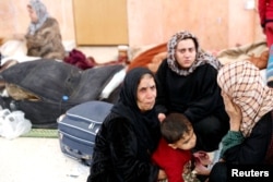 Civilians who escaped from Islamic State militants rest at a mosque in Raqqa, Syria, Oct. 12, 2017.
