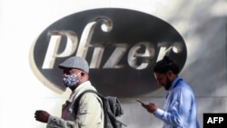People walk by the Pfizer world headquarters in New York on Nov. 9, 2020.