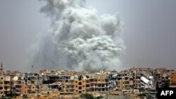 Asap membubung tinggi setelah serangan udara koalisi pimpinan AS terhadap kota Raqqa, Suriah, 28 Juli 2017.