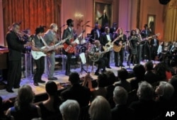 FILE - Then-President Barack Obama and then-first lady Michelle Obama listen to a performance during the White House Music Series saluting blues music in recognition of Black History Month, in the East Room of the White House in Washington, Feb. 21, 2012.