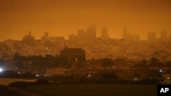 FILE - In this Sept. 9, 2020, file photo, taken at 11:18 a.m., is a dark orange sky above Crissy Field and the city caused by heavy smoke from wildfires in San Francisco. (AP Photo/Eric Risberg, File)