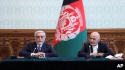 FILE - Afghan President Ashraf Ghani, right, and political rival Abdullah Abdullah, speak after they signed a power-sharing agreement at the presidential palace in Kabul, Afghanistan, May 17, 2020.