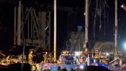First responders work outside an Amazon fulfillment center after it was heavily damaged when a strong thunderstorm moved through the area, Dec. 10, 2021, in Edwardsville, Ill.
