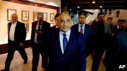 FILE - Iraq's Prime Minister Adel Abdul-Mahdi, center, leaves the parliament building in Baghdad, Iraq, Oct. 2, 2018.
