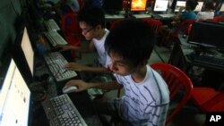 FILE - two Vietnamese students use Facebook at an internet cafe near their dormitory while they could not log in Facebook from their mobile phones because of firewall in Hanoi, Vietnam.