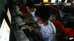 In this Sept. 27, 2012 photo, two Vietnamese students use Facebook at an internet cafe near their dormitory while they could not log in Facebook from their mobile phones because of firewall in Hanoi, Vietnam.