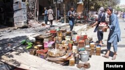 Afghan shopkeepers try to recover items from burning shops after a Taliban attack in Ghazni city, Afghanistan, Aug. 14, 2018.