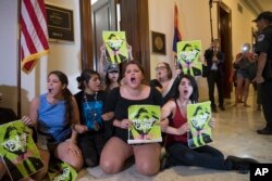 Activists protest against the Republican health care bill outside the offices of Sen. Jeff Flake, R-Ariz., and Sen. Ted Cruz, R-Texas, July 10, 2017, on Capitol Hill in Washington.