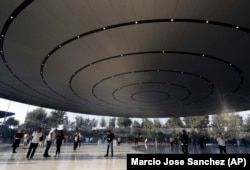 People arrive for a new product announcement at the Steve Jobs Theater on the new Apple campus.