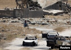 Burnt cars are seen in Quneitra, Syria, July 27, 2018.