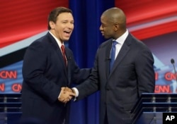Florida Republican gubernatorial candidate Ron DeSantis, left, shakes hands with Democratic gubernatorial candidate Andrew Gillum after a CNN debate, Sunday, Oct. 21, 2018, in Tampa, Florida.