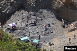 An aerial view shows ecological damage and people at an illegal gold mine in a rural area of Santander de Quilichao, in the department of Cauca, Feb. 13, 2015.
