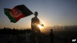 A man waves an Afghan flag during Independence Day celebrations in Kabul, Afghanistan, Monday, Aug. 19, 2019. (AP Photo/Rafiq Maqbool)