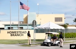 Security guards stand outside a former Job Corps site that now houses child immigrants, June 18, 2018, in Homestead, Florida. It is not known if the children crossed the border as unaccompanied minors or were separated from family members.
