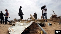 Des journalistes regardant les débris sur le site du crash du vol AH 5017d'Air Algérie dans la région de Gossi, Mali, à l'ouest de Gao, le 26 Juillet 2014.