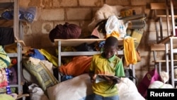 FILE - A displaced boy, who fled with others from his village in northern Burkina Faso following attacks by assailants, poses at a school on the outskirts of Ouagadougou, Burkina Faso, June 15, 2019. 