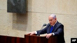 Israeli Prime Minister Benjamin Netanyahu speaks during a swearing in ceremony of his new unity government with election rival Benny Gantz, at the Knesset, Israel's parliament, in Jerusalem, Sunday, May 17, 2020. Netanyahu is finally swearing in his…
