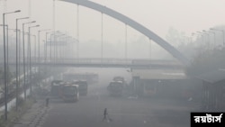 Seorang pria menyapu di terminal bus pada pagi yang berkabut di New Delhi, India, 16 November 2021. REUTERS/Anushree Fadnavis