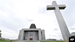 FILE - People walk by the Temple of Divine Providence, a major church in Warsaw, Poland, May 13, 2019. 