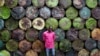 Steel barrel vendor Lassiney Diarra poses for a picture in front of barrels in Bamako, Mali, Aug. 13, 2013.