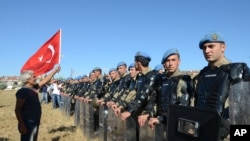 A protester argues at a paramilitary police barricade as security block thousands of people outside the Silivri jail complex in Silivri, Turkey, Aug. 5, 2013. 