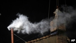 Asap putih terlihat dari cerobong asap di atap Kapel Sistina, di Lapangan Santo Petrus di Vatikan (13/3).